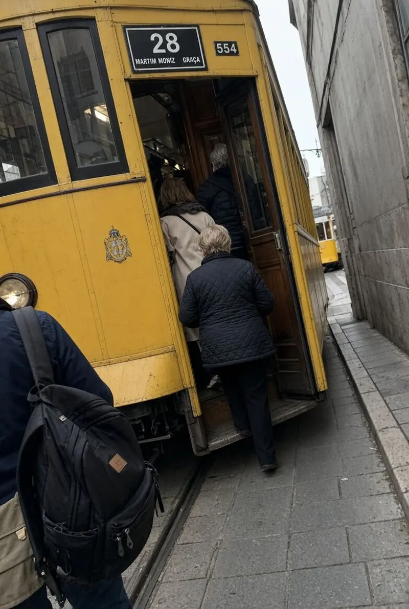 A friend steps onto the yellow tram in Lisbon.